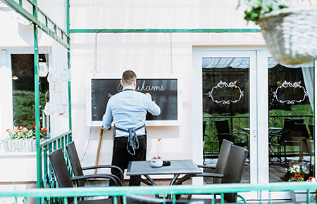 Small business owner standing outside storefront representing SBA loan financing